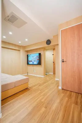 a bedroom with a bed and a flat screen tv at Sakura Suite in Tokyo