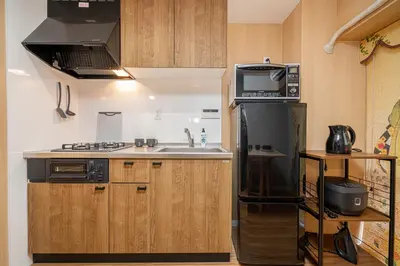 a kitchen with a black refrigerator and a sink at Sakura Suite in Tokyo
