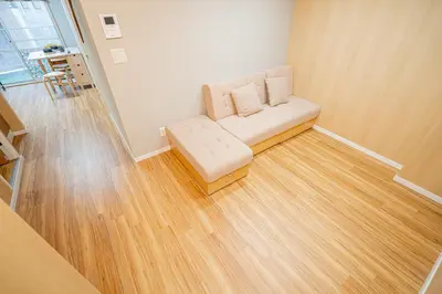 a living room with a couch and a wooden floor at Sakura Suite in Tokyo