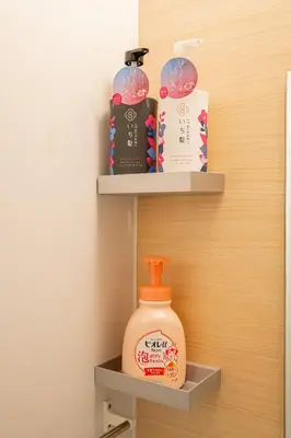 a shelf with a bottle of detergent and other items at Sakura Suite in Tokyo