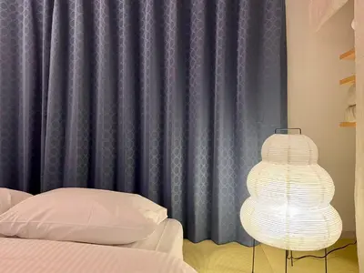 a bedroom with a bed and a blue curtain at 浅草寺3分｜浅草駅6分｜開放的｜畳寝室｜2-6人｜成田&羽田空港直通 in Tokyo