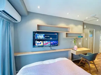 a bedroom with a tv on a blue wall at ZDt-612-SJ0152 in Tokyo