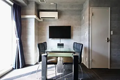 a dining room with a table and chairs and a tv at Regalo shibaura 801 in Tokyo