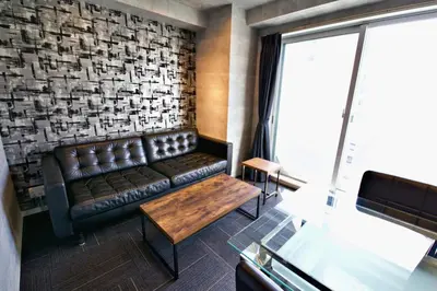 a living room with a leather couch and a table at Regalo shibaura 801 in Tokyo
