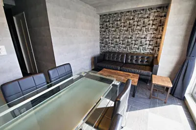 a waiting room with a table and leather chairs at Regalo shibaura 801 in Tokyo