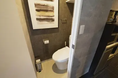 a bathroom with a toilet and a painting on the wall at Regalo shibaura 801 in Tokyo