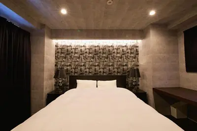 a bedroom with a large white bed with two lamps at Regalo shibaura 801 in Tokyo