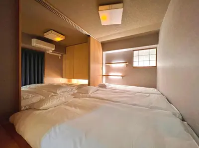 a room with three beds in it with a window at 浅草スカイツリービューテラス 浅草寺3分 浅草駅6分 2-10人 成田&羽田空港直通 in Tokyo