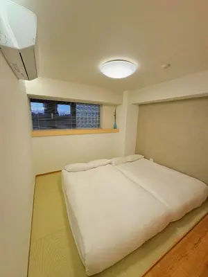a bedroom with a large white bed with a window at 浅草スカイツリービューテラス 浅草寺3分 浅草駅6分 2-10人 成田&羽田空港直通 in Tokyo