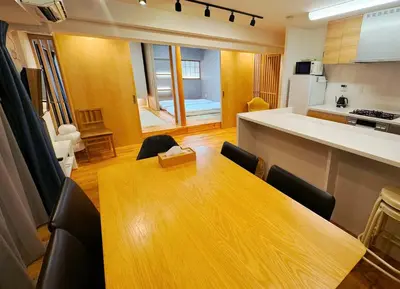 a kitchen and dining room with a wooden table and chairs at 浅草スカイツリービューテラス 浅草寺3分 浅草駅6分 2-10人 成田&羽田空港直通 in Tokyo