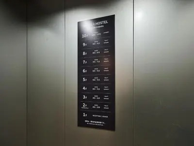a sign for a hotel on a wall at Hotel Plus Hostel TOKYO AKIHABARA in Tokyo