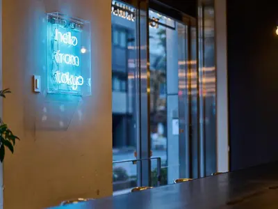 a blue sign on a wall next to a table at Hotel Plus Hostel TOKYO AKIHABARA in Tokyo
