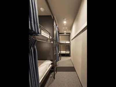 a small room with two bunk beds and a hallway at Hotel Plus Hostel TOKYO AKIHABARA in Tokyo