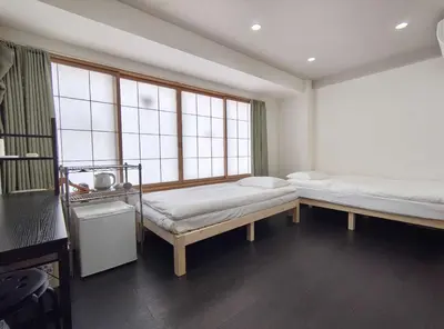 two beds in a room with two windows at peter hotel akihabara in Tokyo