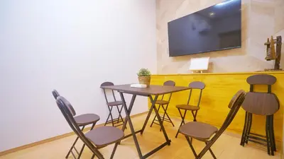 a table and chairs with a television on a wall at \u4e0a\u91ce\u5200\u516b\u6bd8\u6c99\u9580\u5929\u30db\u30c6\u30eb in Tokyo