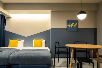 a bedroom with a bed with yellow pillows and a table at Section L Tsukiji in Tokyo