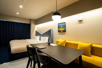 a room with a bed and a table and a couch at Section L Tsukiji in Tokyo