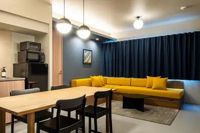 a living room with a yellow couch and a table at Section L Tsukiji in Tokyo