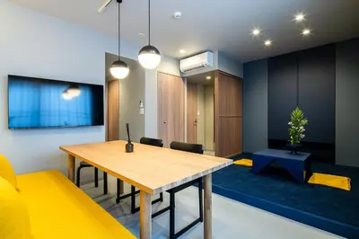 a dining room with a wooden table and yellow chairs at Section L Tsukiji in Tokyo