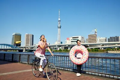 two women riding a bike with a giant donut at Section L Kuramae - Asakusa in Tokyo