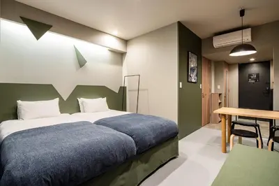 a bedroom with a large bed and a table at Section L Kuramae - Asakusa in Tokyo