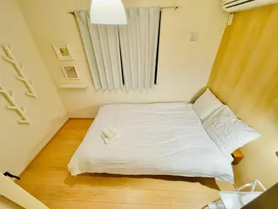 a small bedroom with a white bed and a window at One-Ikebukuro TS0230 in Tokyo
