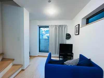 a living room with a blue couch and a window at One-Ikebukuro TS0230 in Tokyo
