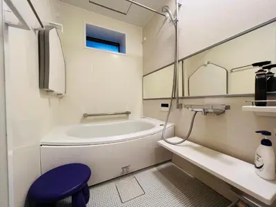 a bathroom with a white tub and a blue stool at One-Ikebukuro TS0230 in Tokyo