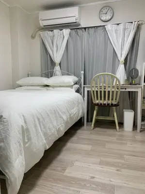 a bedroom with a bed and a desk with a clock at COCO Nakameguro 202 in Tokyo
