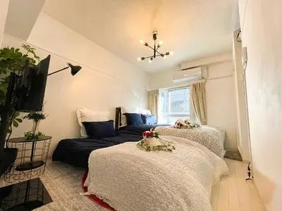 a bedroom with two beds and a tv at BEST LOCATED SHINJUKU CENTRAL Full-Furnished APARTMENT 3minWalk to Station2 in Tokyo