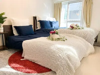 a bedroom with two beds with flowers on them at BEST LOCATED SHINJUKU CENTRAL Full-Furnished APARTMENT 3minWalk to Station2 in Tokyo