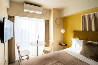a bedroom with a bed and a table and a window at Section L Hamamatsucho in Tokyo