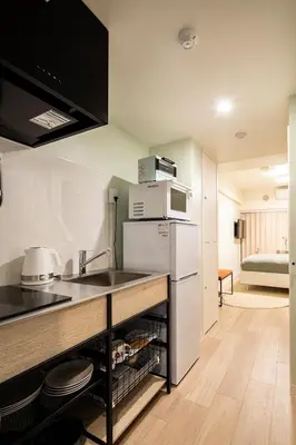 a kitchen with a counter and a sink and a refrigerator at Section L Hamamatsucho in Tokyo