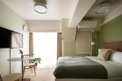 a bedroom with a bed and a table and a window at Section L Hamamatsucho in Tokyo