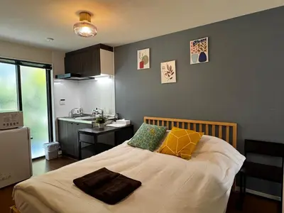 a bedroom with a large bed with yellow and green pillows at Lucky you! YOTSUYA in Tokyo