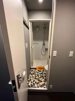 a small bathroom with a shower and a toilet at Rhodes Otsuka Hotel in Tokyo