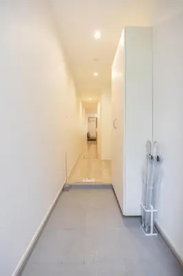 a hallway with white walls and a tile floor at \u6e0b\u8c37 \u5e83\u308150m2 2LDK \u4ee3\u3005\u6728\u516c\u5712\u99c5\u5f92\u6b695\u5206 \u5bb6\u65cf\u306b\u304a\u3059\u3059\u3081 in Tokyo