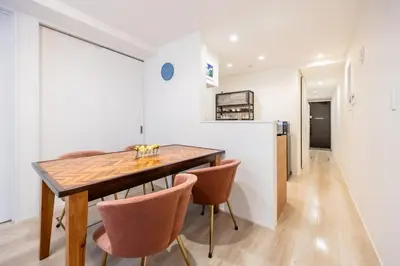 a kitchen and dining room with a wooden table and chairs at \u6e0b\u8c37 \u5e83\u308150m2 2LDK \u4ee3\u3005\u6728\u516c\u5712\u99c5\u5f92\u6b695\u5206 \u5bb6\u65cf\u306b\u304a\u3059\u3059\u3081 in Tokyo