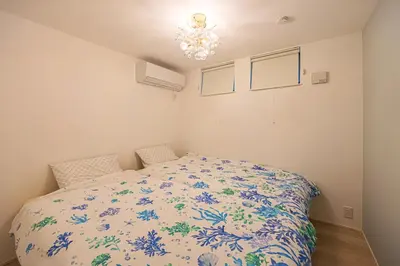 a bedroom with a bed with a floral bedspread at \u6e0b\u8c37 \u5e83\u308150m2 2LDK \u4ee3\u3005\u6728\u516c\u5712\u99c5\u5f92\u6b695\u5206 \u5bb6\u65cf\u306b\u304a\u3059\u3059\u3081 in Tokyo
