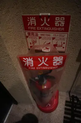 a sign that says fire extinguisher on a wall at Guest House Tokyo Samurai in Tokyo