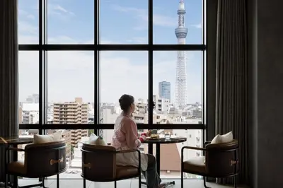 a man sitting at a table in front of a window at OMO3 Asakusa by Hoshino Resorts in Tokyo
