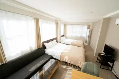 a hotel room with two beds and a couch at ILIMA Higashi Nakano - Vacation STAY 89452v in Tokyo
