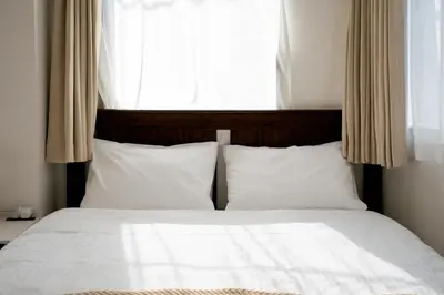 a bed with white sheets and pillows in front of a window at ILIMA Higashi Nakano - Vacation STAY 89452v in Tokyo