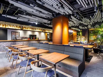 a restaurant with wooden tables and chairs at &Here TOKYO UENO in Tokyo