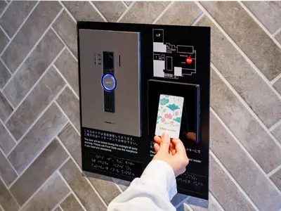a person holding a remote control in a box at &Here TOKYO UENO in Tokyo
