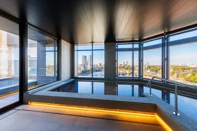 a swimming pool in a building with windows at &Here TOKYO UENO in Tokyo