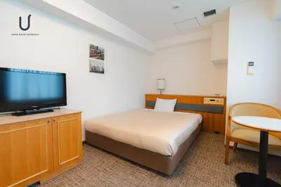 a hotel room with a bed and a flat screen tv at Forest Hongo by unito in Tokyo