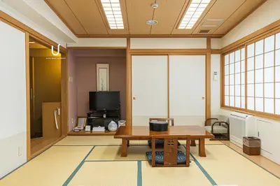 a living room with a table and a tv at Forest Hongo by unito in Tokyo