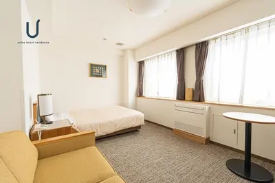 a hotel room with a bed and a couch and a table at Forest Hongo by unito in Tokyo