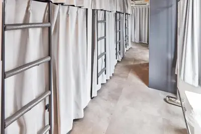 a row of white curtains in a hallway at Tora Hotel Asakusa in Tokyo